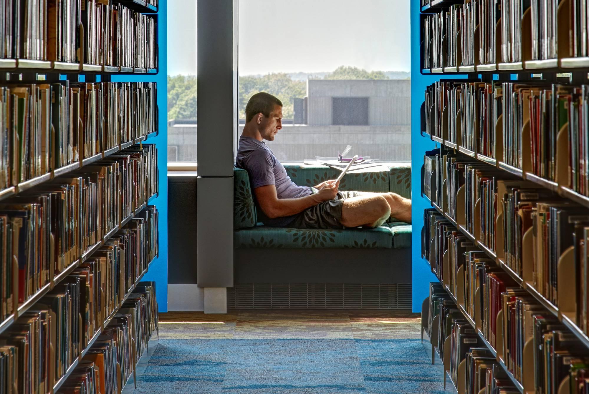 Student sitting near a window in the Library